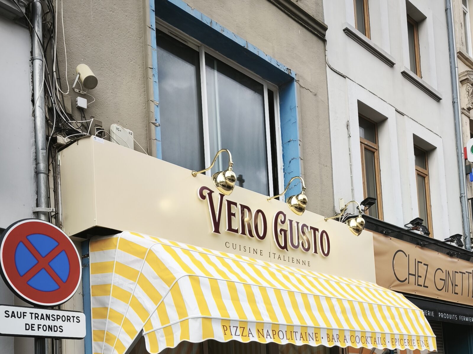 Vero Gusto — l'enseigne et le store corbeille vus depuis le trottoir, dans une rue commerçante du centre-ville
