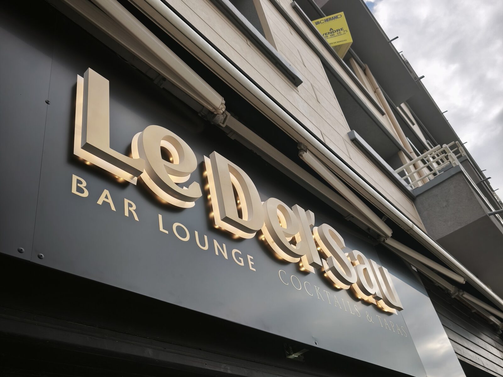 Lettres relief Le Del'Sau en contre-plongée : épaisseur des lettres et halo LED sur le bandeau